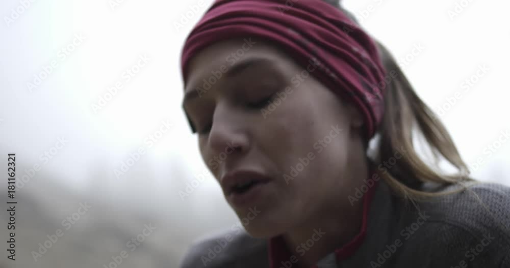 Athlete girl resting after run. Detail on face breathing.Real people woman runner sport training in autumn or winter in wild mountain outdoors nature, bad foggy weather.4k 60p slow motion video