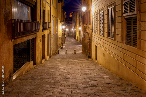 Siena. Old city street at night. © pillerss