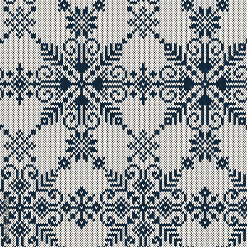 Seamless knitted pattern with blue snowflakes on a white background