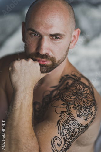 Fotografie Bald beefy man with naked torso sitting in the room 7.