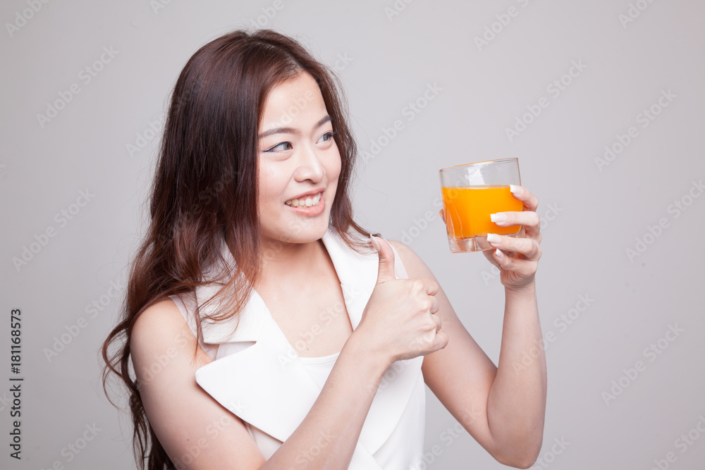 Young Asian woman thumbs up drink orange juice. Young Asian woman thumbs up drink orange juice.
