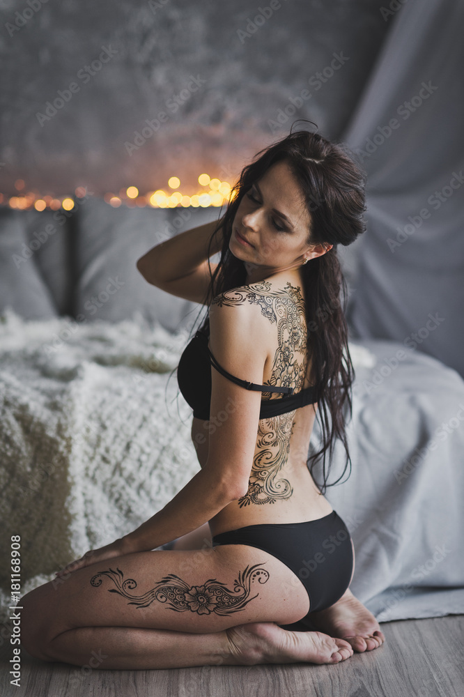 Naklejka premium Portrait of a beautiful girl in her underwear sitting on the floor by the bed