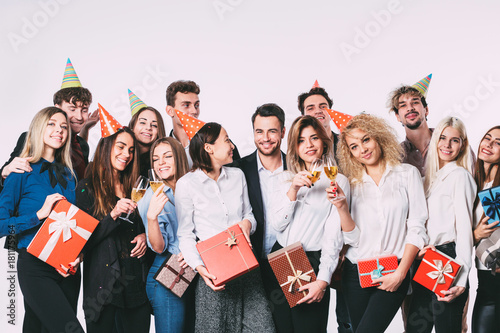 Group of happy young people celebrating and having fun together over white background.
