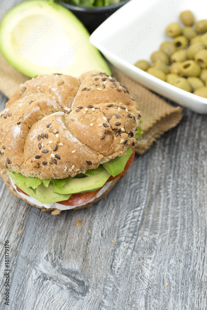 Sandwiches with avocado, camembert, vegetable salad and salami. Breakfast on the rustic table.