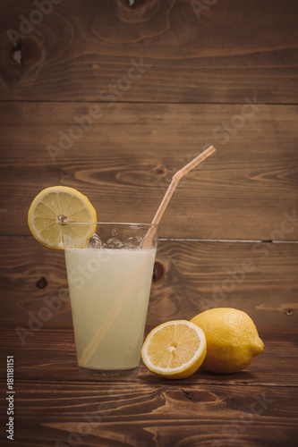 Glass of fresh lemon juice with sliced lemon half