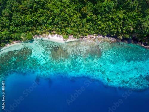 Tropical island paradise background, aerial top view of secluded white sand beach.