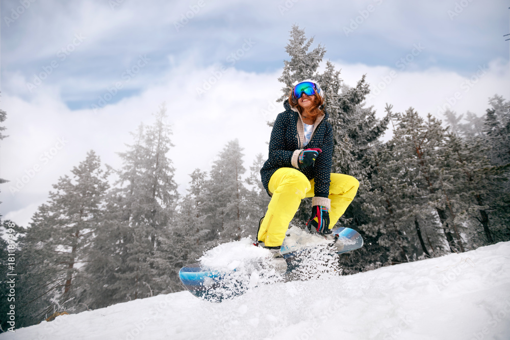 girl snowboarder in jump at ski resort in the mountain