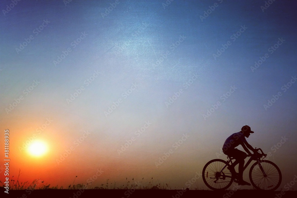 Fototapeta premium Silhouette of a cyclist riding a bicycle at sunset
