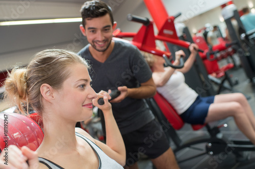 Photos helping a woman lift the dumbbells