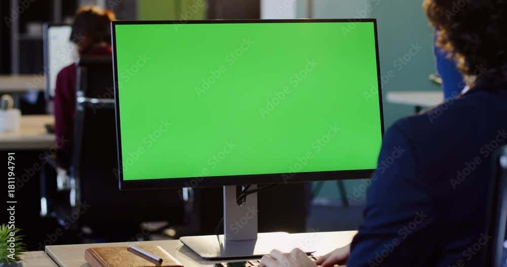 Businessman working on the PC computer and typing on the keyboard in the office. Rear view. Computer green screen, chroma key. Indoor Businessman working on the PC computer and typing on the keyboard in the office. Rear view. Computer green screen, chroma key. Indoor