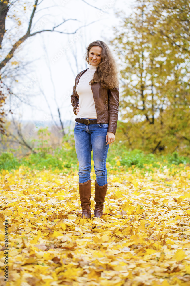 Autumn fashion image of young woman walking in the park Autumn fashion image of young woman walking in the park