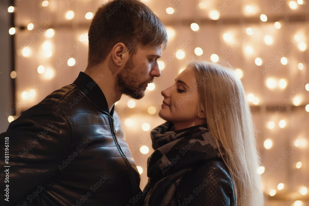 Fototapeta premium An attractive couple in love embrace and enjoy an intimate moment together, against the backdrop of city lights