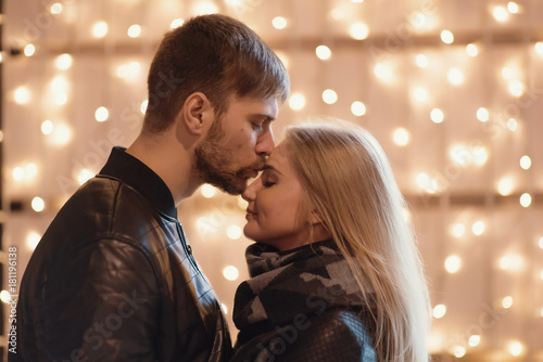 An attractive couple in love embrace and enjoy an intimate moment together  against the backdrop of city lights