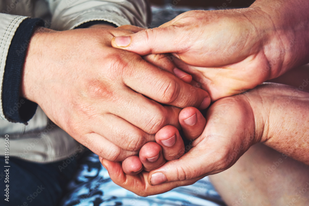 Closeup hands of medical doctor carefully holding patient's hands.