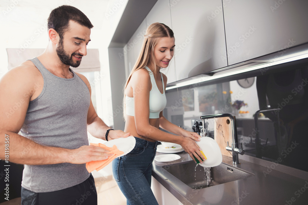 A man and a woman in the kitchen in the morning. They wash the dishes after breakfast. A man and a woman in the kitchen in the morning. They wash the dishes after breakfast.