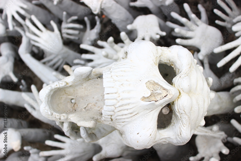 Naklejka premium Abstract sculpture of white skull and hands.