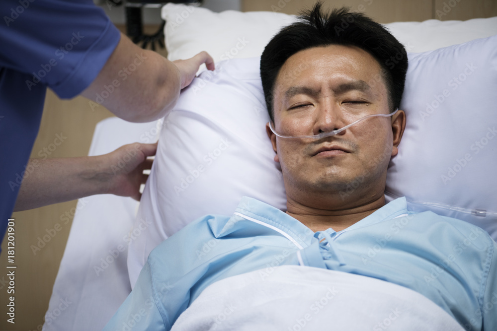 A sick Asian man in a hospital A sick Asian man in a hospital