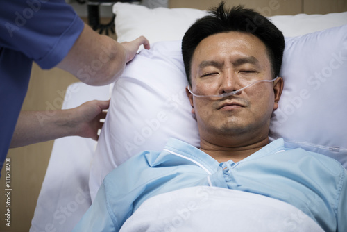 A sick Asian man in a hospital