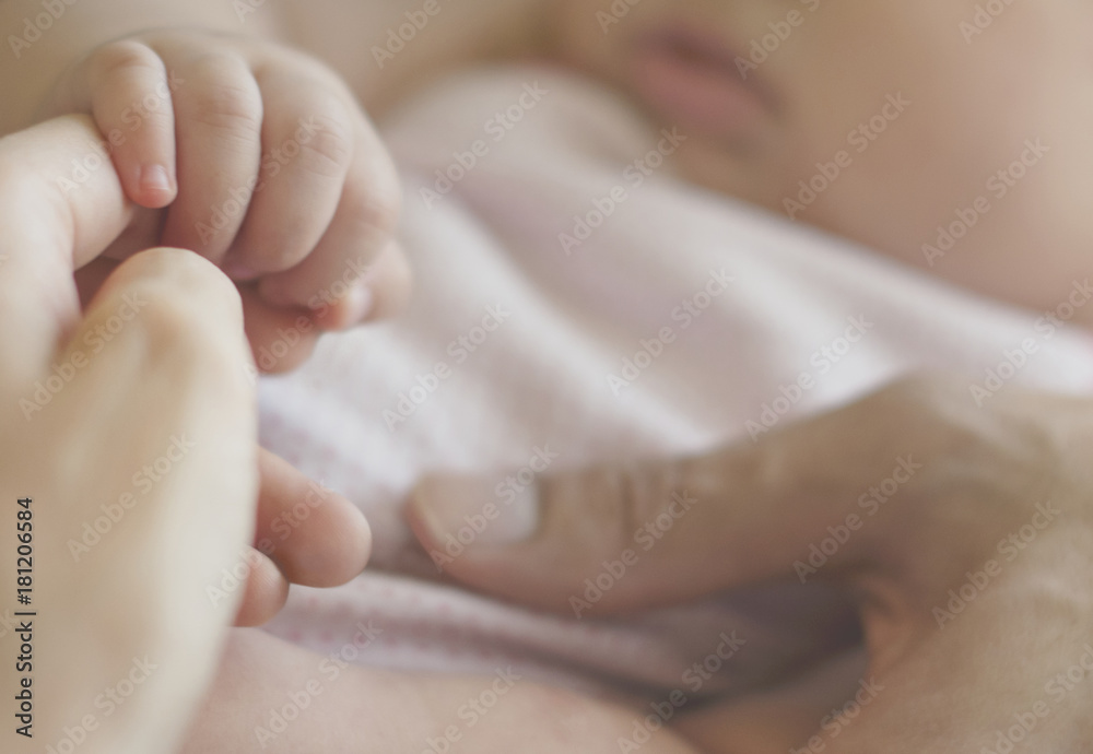 Closeup of baby holding mother hands Closeup of baby holding mother hands