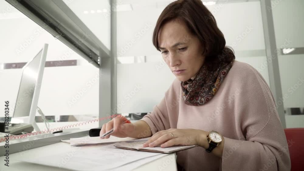A pretty woman gets a loan to buy a home. A woman checks the passport data in the contract. A pretty woman gets a loan to buy a home. A woman checks the passport data in the contract.