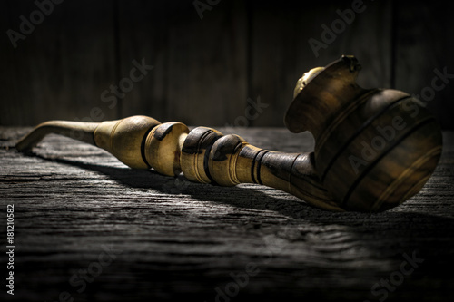 Smoking pipe on wooden background