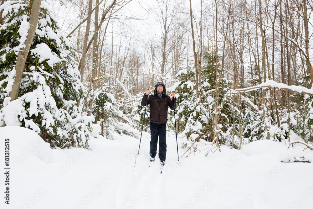 Young man cross-country skiing in the forest 