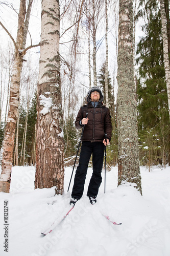 Young man cross-country skiing in the forest 