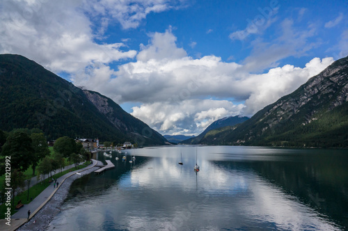 Beautiful landscape Achensee lake, alpine mountains, blue sky and clouds, reflections in water. Tirol, Austria.