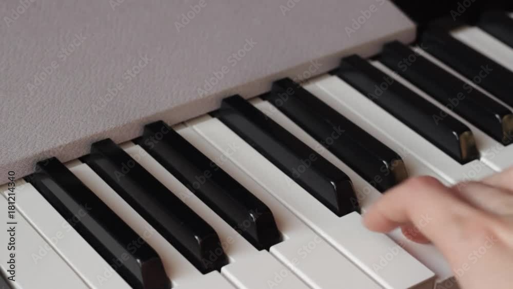 Beautiful fingers on white and black piano keys or a synthesizer play a melody