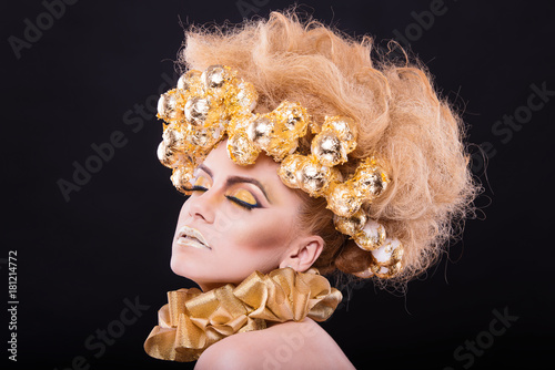 eyes closed beauty model with perfect skin and foil and amazin hair. makeup is amazing with gold colors on black background