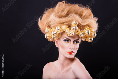 perfect skin model with amazing hair and gold accents over the face and makeup with gold and red colors on black background