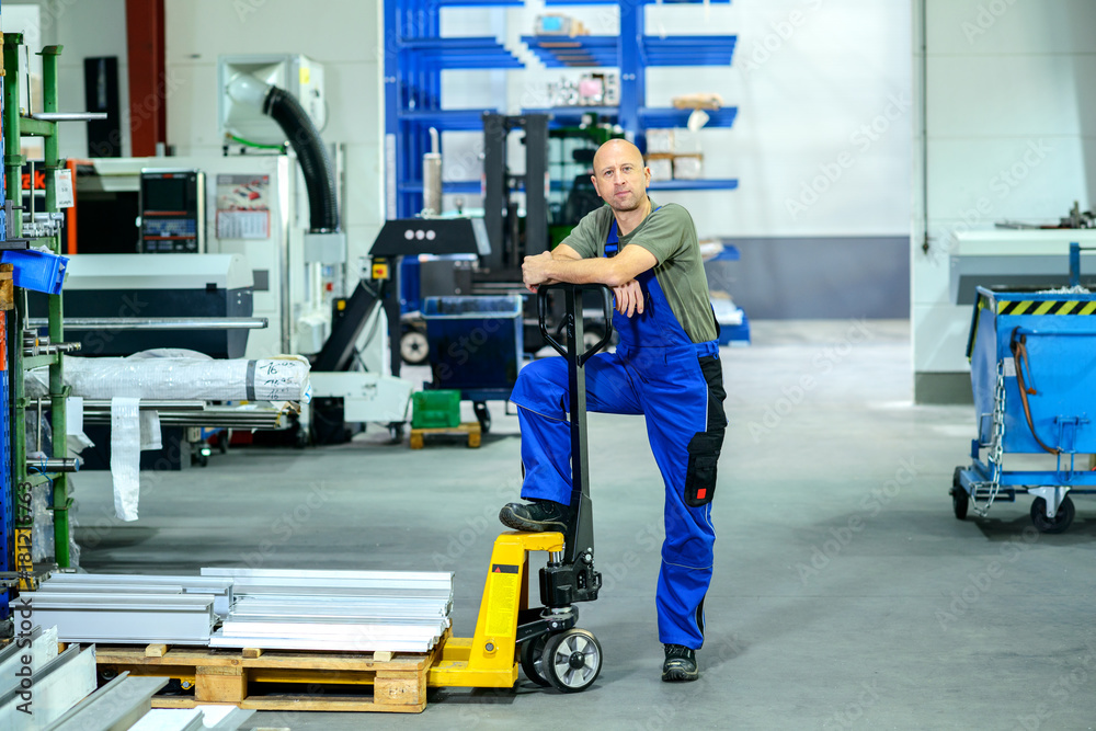 worker in factory with hand lift worker in factory with hand lift