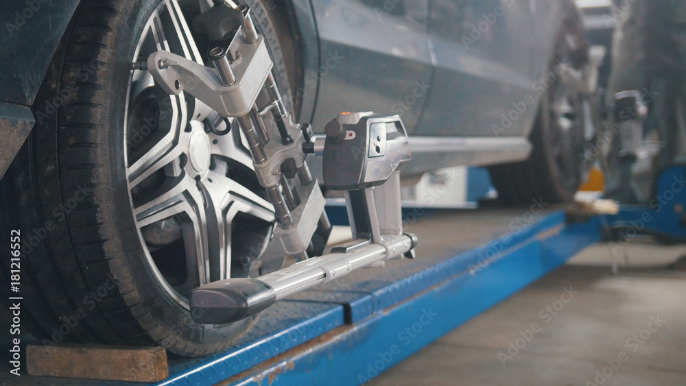 Fototapeta premium Checking the wheel in garage automobile service, close up