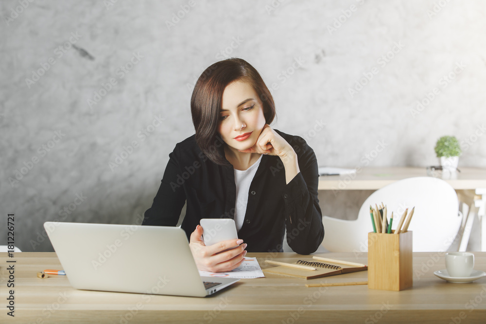 Beautiful businesswoman using phone at workplace Beautiful businesswoman using phone at workplace