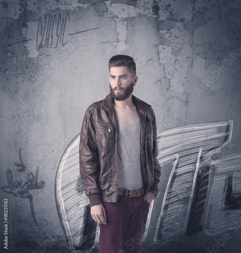 Fashion model standing at graffiti wall