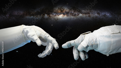 two near touching hands in space suits, Michelangelo touch pose with Milky Way galaxy