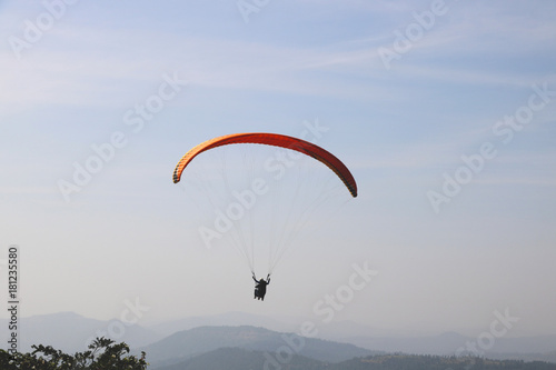  paraglider is flying in the blue sky against the background of clouds. Paragliding in the sky on a sunny day.