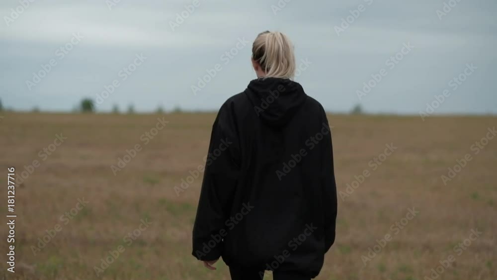 back view - female blondie going in field back view - female blondie going in field