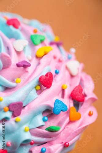 Closeup cupcake creamy multicolored top with colorful hearts and sprinkles