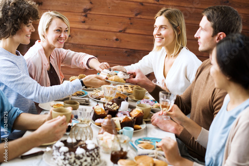 Friendly people talking by Christmas dinner while eating homemade pastry