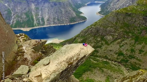 Trolltunga. Norway. The guy and the girl sitting on the edge of the Trolltunga. aerial vie. beautiful landscape of Norway