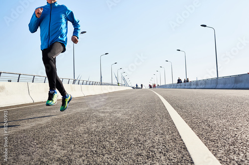 Part of wide road and active man running along energetically