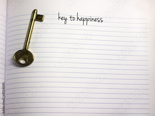 key to happiness handwriiten text on a blank white empty paper with a key on the side and copy space photo