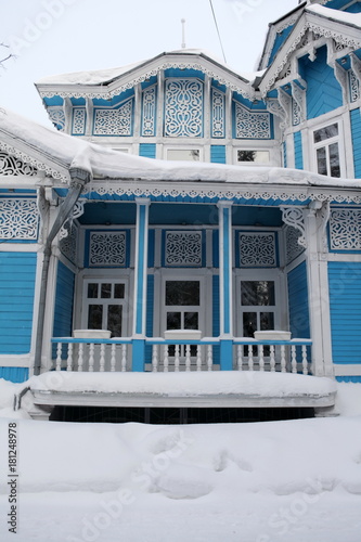 Vintage wooden Russian-German house with ornamental frames in Tomsk city, Russia. Russian folk style in architecture. Tomsk landmark, Tomsk monument, cityscape, view. Snow winter, cold season. Siberia