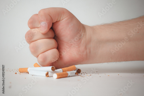 Man's hand crushing cigarettes. quit Smoking.
