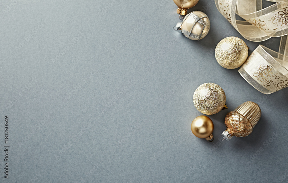 Golden Christmas Ornaments with Satin Ribbon on Gray Background Golden Christmas Ornaments with Satin Ribbon on Gray Background