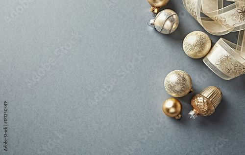 Golden Christmas Ornaments with Satin Ribbon on Gray Background