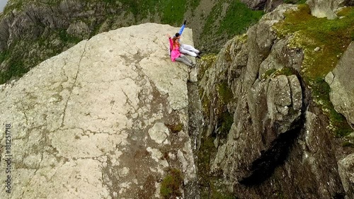 Trolltunga. Norway. The guy and the girl sitting on the edge of the Trolltunga. aerial vie. beautiful landscape of Norway