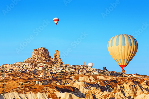 Colorful Hot air balloons flying at Uchisar castle in ancient town of Cappadocia, Turkey