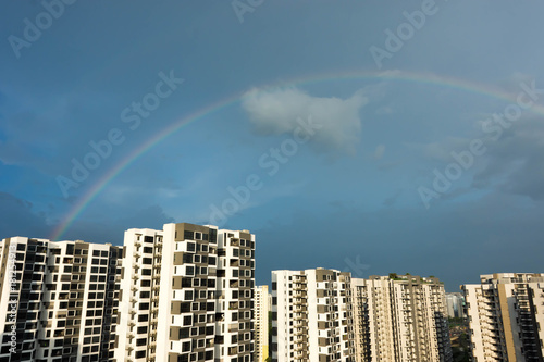 Skyline photo of condominium with rainbow and blue sky
